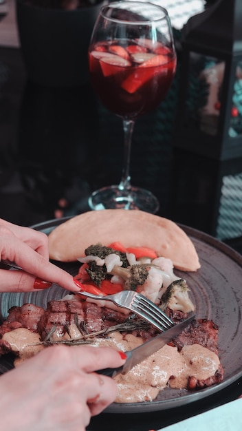 une assiette de nourriture avec un verre de vin rouge en arrière-plan