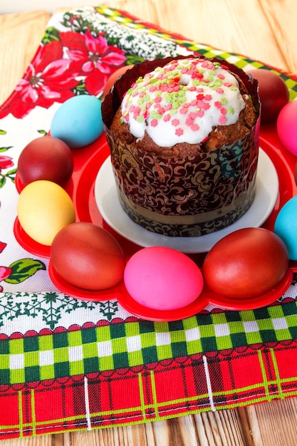 Assiette de Pâques avec gâteau et oeufs peints sur une nappe lumineuse avec un imprimé floral