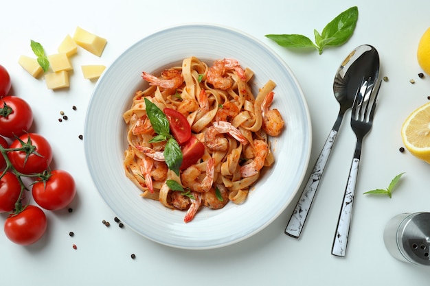 Assiette de pâtes aux crevettes et ingrédients sur blanc