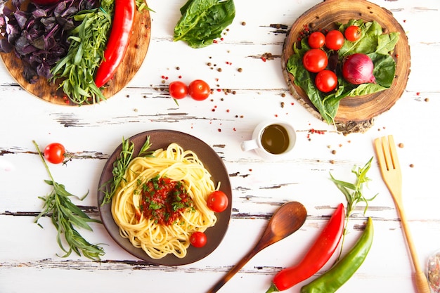 Assiette avec des pâtes. Cerise, piment, tomate, basilic, épices, estragon, oignon