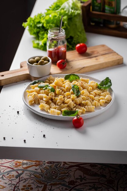 Assiette de pâtes italiennes sur une table de cuisine blanche