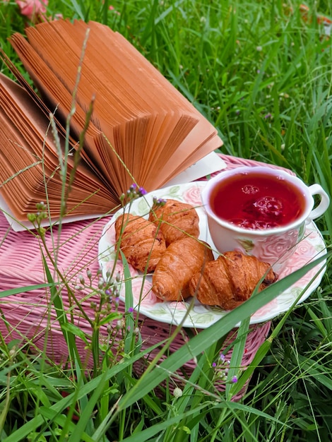 Une assiette de pâtisseries et une tasse de thé sur une table avec un livre dessus.