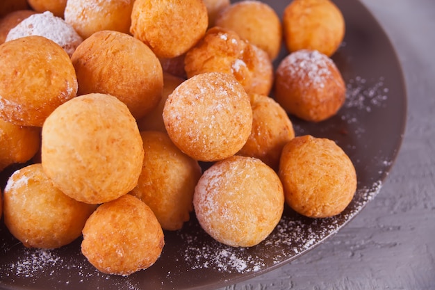 Assiette avec des petites boules de beignes au fromage blanc