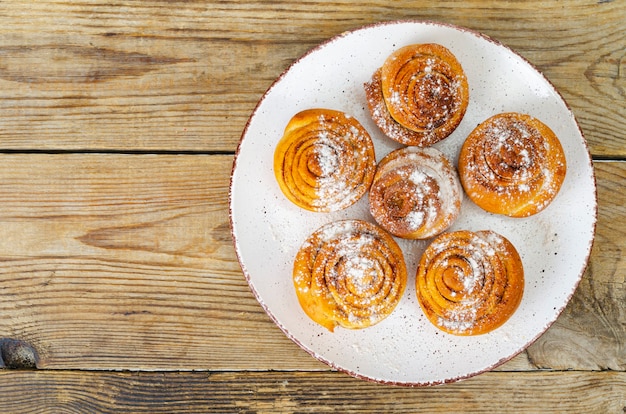 Assiette de petits pains à la cannelle maison sur table en bois