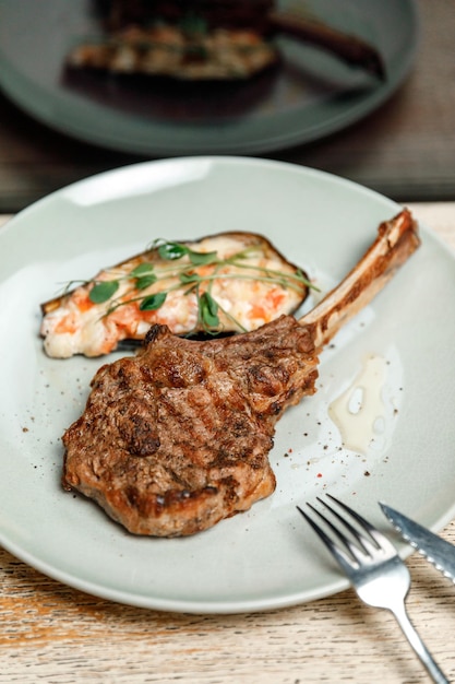 Assiette de plat avec steak de viande sur l'os au restaurant