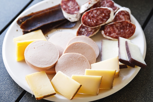 Assiette pleine de collations savoureuses - Fromage, saucisse, salami et viande.