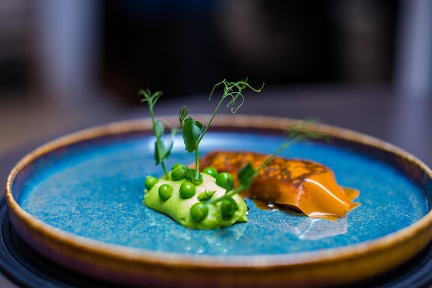 une assiette avec des pois et des carottes avec un légume vert