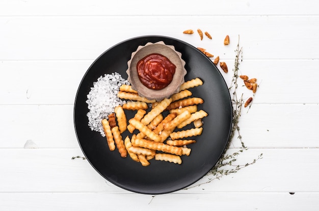 Assiette de pommes de terre françaises avec vue de dessus de ketchup et de sel de mer