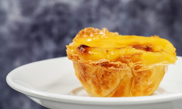 Avec une assiette portugaise Pastel de Nata quiche Pastel de Belem est une pâtisserie monastique et culte sous forme de tasses avec un dessus brûlé et une croûte de pâtisseries croustillante Desserts sucrés avec de la crème aux œufs