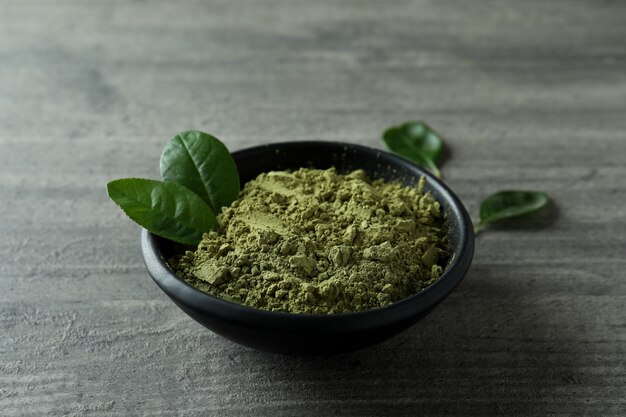 Assiette de poudre de matcha sur fond texturé gris