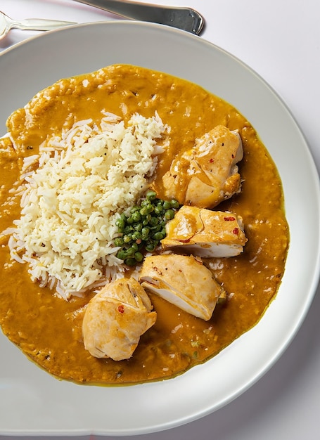 assiette de poulet avec sauce au curry et riz vue de dessus isolée_ai_generated