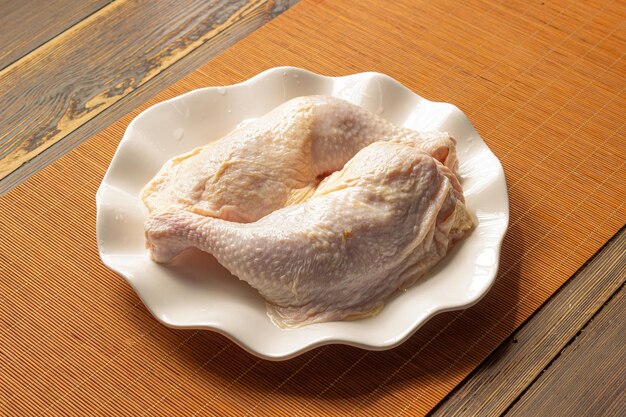 Une assiette de poulet sur une table avec une nappe en bois