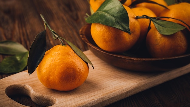Assiette avec quelques mandarines sur table en bois