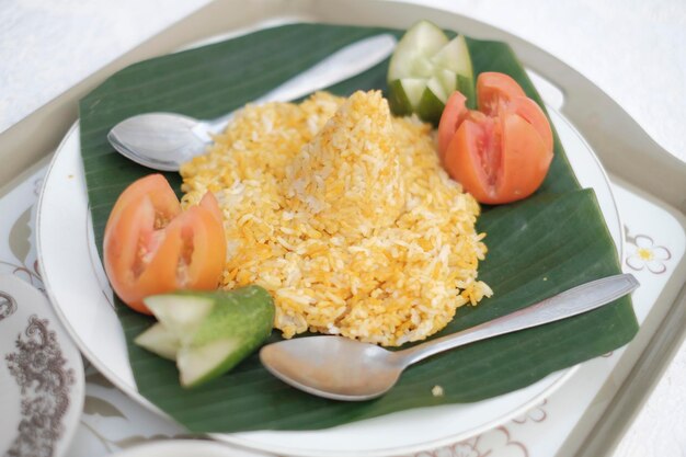 Une assiette de riz avec une cuillère et quelques concombres dessus.