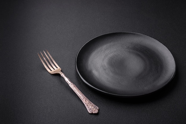 Assiette ronde en céramique vide sur fond de béton texturé foncé