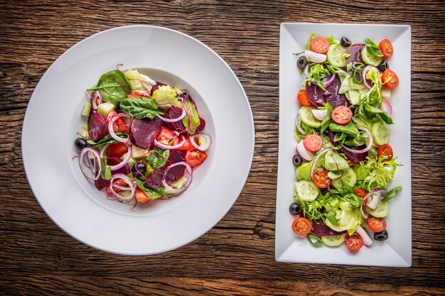 Assiette de salade aux légumes sur table en chêne rustique Assortiment d'ingrédients de salade de légumes
