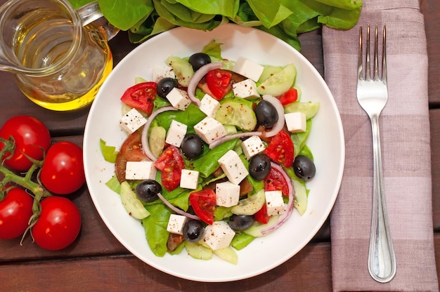 Une assiette de salade avec des olives noires et des tomates dessus