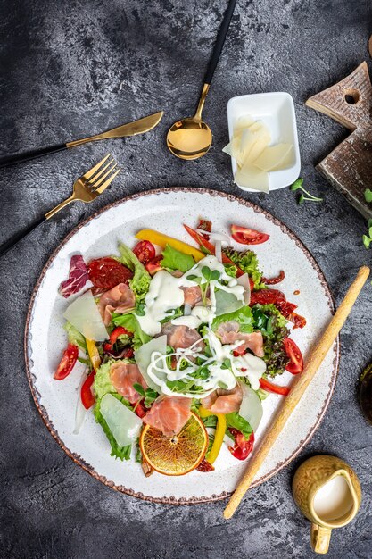 Assiette de salade saine. Recette de fruits de mer frais. Saumon fumé, laitue, tomates séchées et sauce au fromage. La nourriture saine. Mise à plat. Vue de dessus,