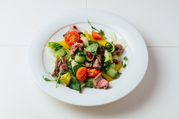 Une assiette de salade avec de la viande et des légumes