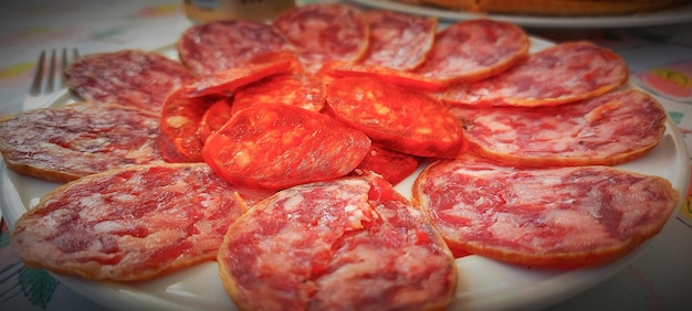 Une assiette de salami et autres viandes sur une table