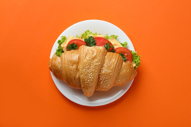 Assiette avec sandwich croissant sur orange