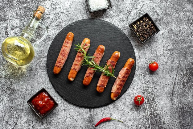 Une assiette de saucisses au bacon et à l'huile d'olive sur une table.