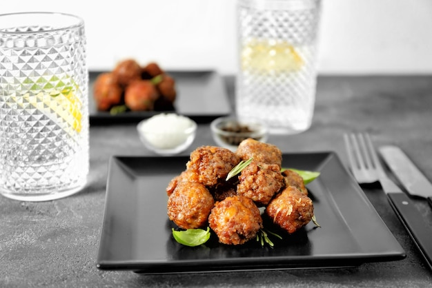 Assiette avec de savoureuses boulettes de fromage à la saucisse sur la table