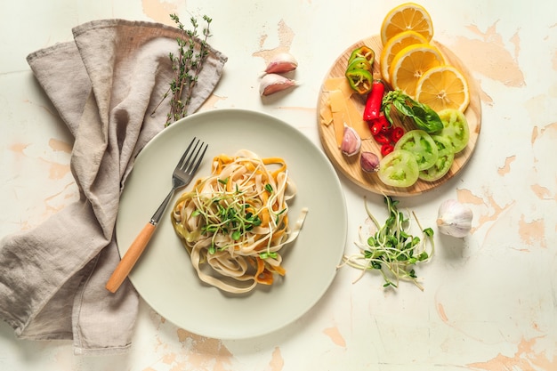 Assiette avec de savoureuses pâtes, fromage et légumes sur table