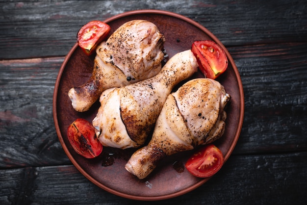 Sur une assiette se trouvent plusieurs morceaux de viande frite, des pilons de poulet, une recette de cuisine