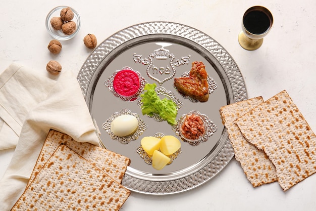 Assiette de Seder de Pâque avec de la nourriture traditionnelle sur une surface blanche