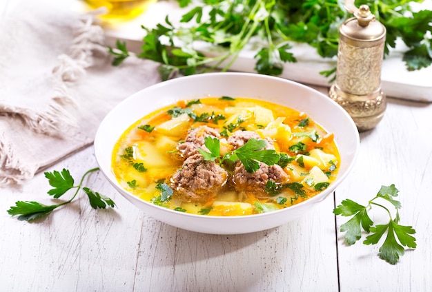 Assiette de soupe aux boulettes de viande sur table en bois