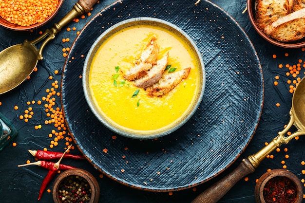 Assiette de soupe aux lentilles rouges aromatiques.Soupe aux lentilles avec des ingrédients