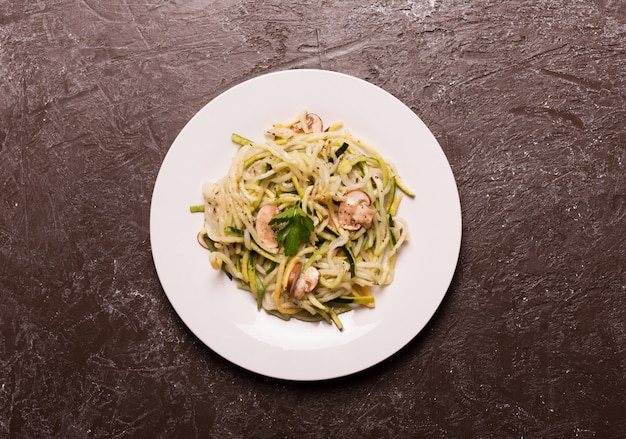 Assiette de spaghettis préparés à partir de courgettes. Vue de dessus, pose à plat