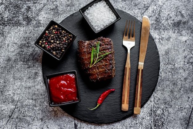 Une assiette de steak avec un couteau et une fourchette à côté