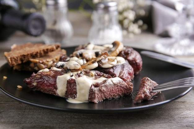 Assiette avec steak Diane sur table en bois