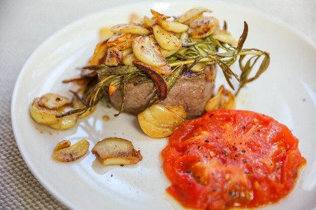 Une assiette de steak avec sauce rouge et une sauce dessus.