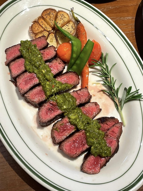 Une assiette de steaks sauce verte et carottes