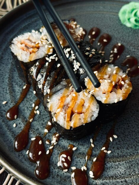 Une assiette de sushi avec une paire de baguettes