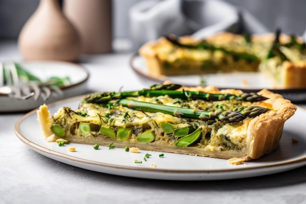 Assiette de tarte aux asperges en croûte feuilletée et asperges vertes fraîches