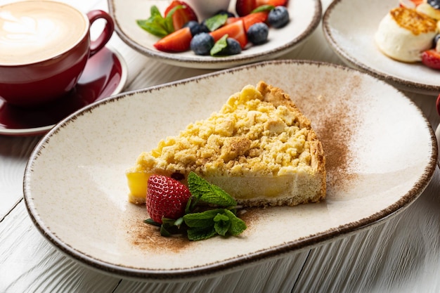 Une assiette de tarte aux fruits avec une tasse de café et une assiette de café.