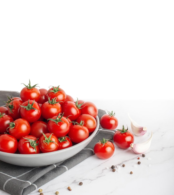 assiette avec tomates cerises et épices sur fond de marbre blanc