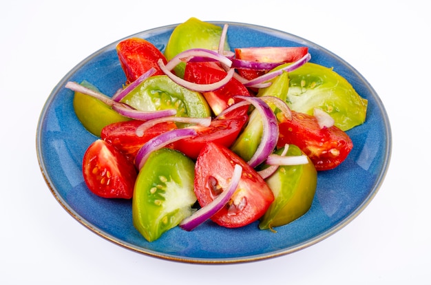 Assiette avec des tranches de tomates mûres de différentes couleurs. Studio photo.