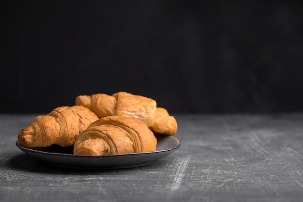 Assiette de trois croissants sur le fond gris