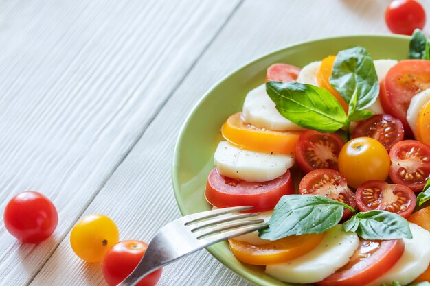 Assiette verte close-up avec salade traditionnelle italienne Caprese