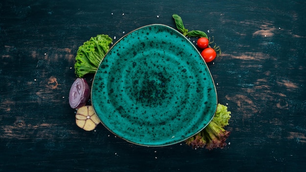 Assiette verte sur un fond en bois avec des légumes Sur une table en bois Vue de dessus Espace de copie