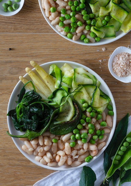 Assiette verte de légumes et de haricots blancs. Vue de dessus.