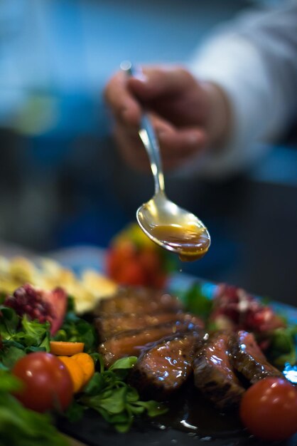 Assiette de viande de bifteck de finition à la main du chef avec vinaigrette Enfin et presque prête à servir à table