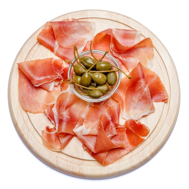 Assiette de viande de crudo de prosciutto italien ou de jambon espagnol sur une planche à découper en bois