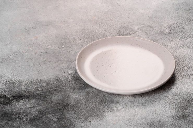 Photo assiette vide blanche dans la table en béton