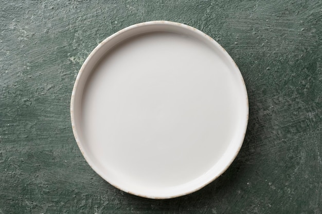 Assiette vide en céramique blanche sur fond vert